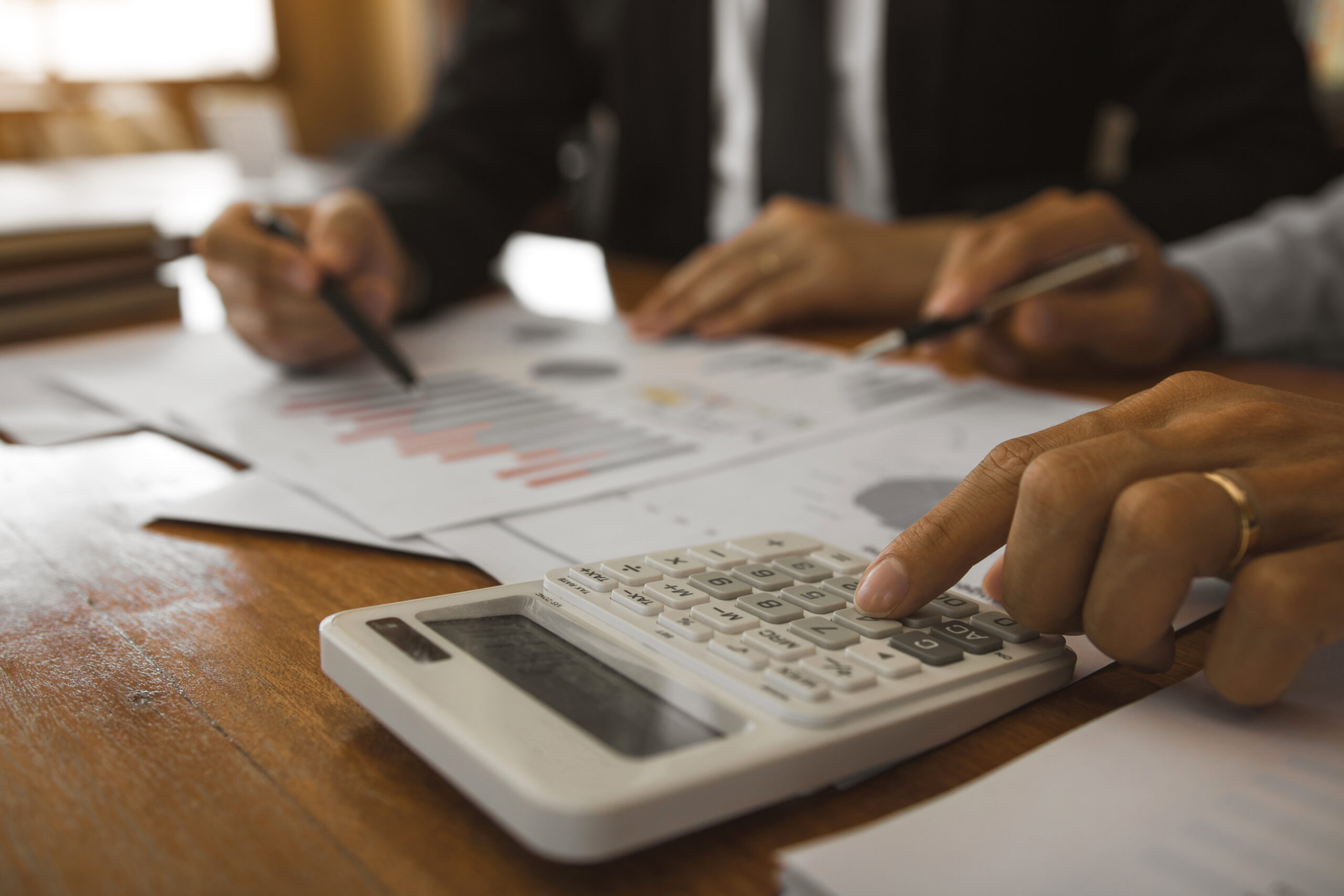 Business partnership pointing to the graph of the company financial statements report and profits earned during in the office.