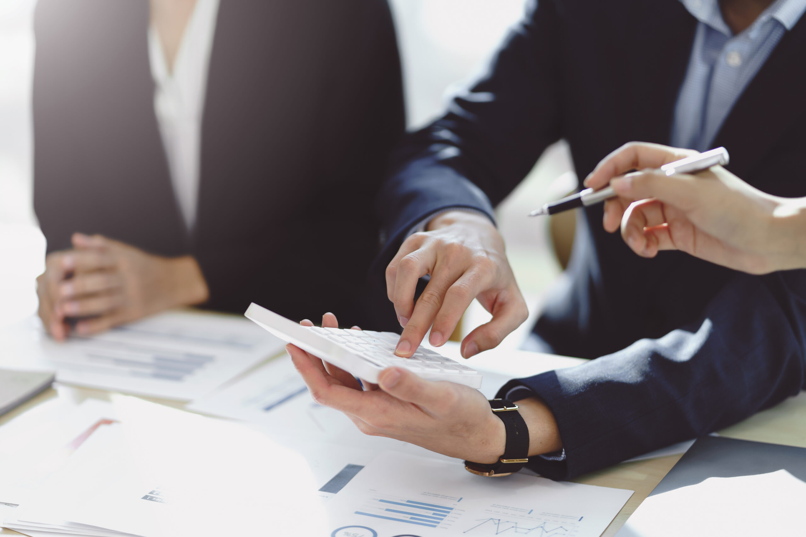 Business people using a calculator Think analyzing income, financial statements, balance sheet, company information.