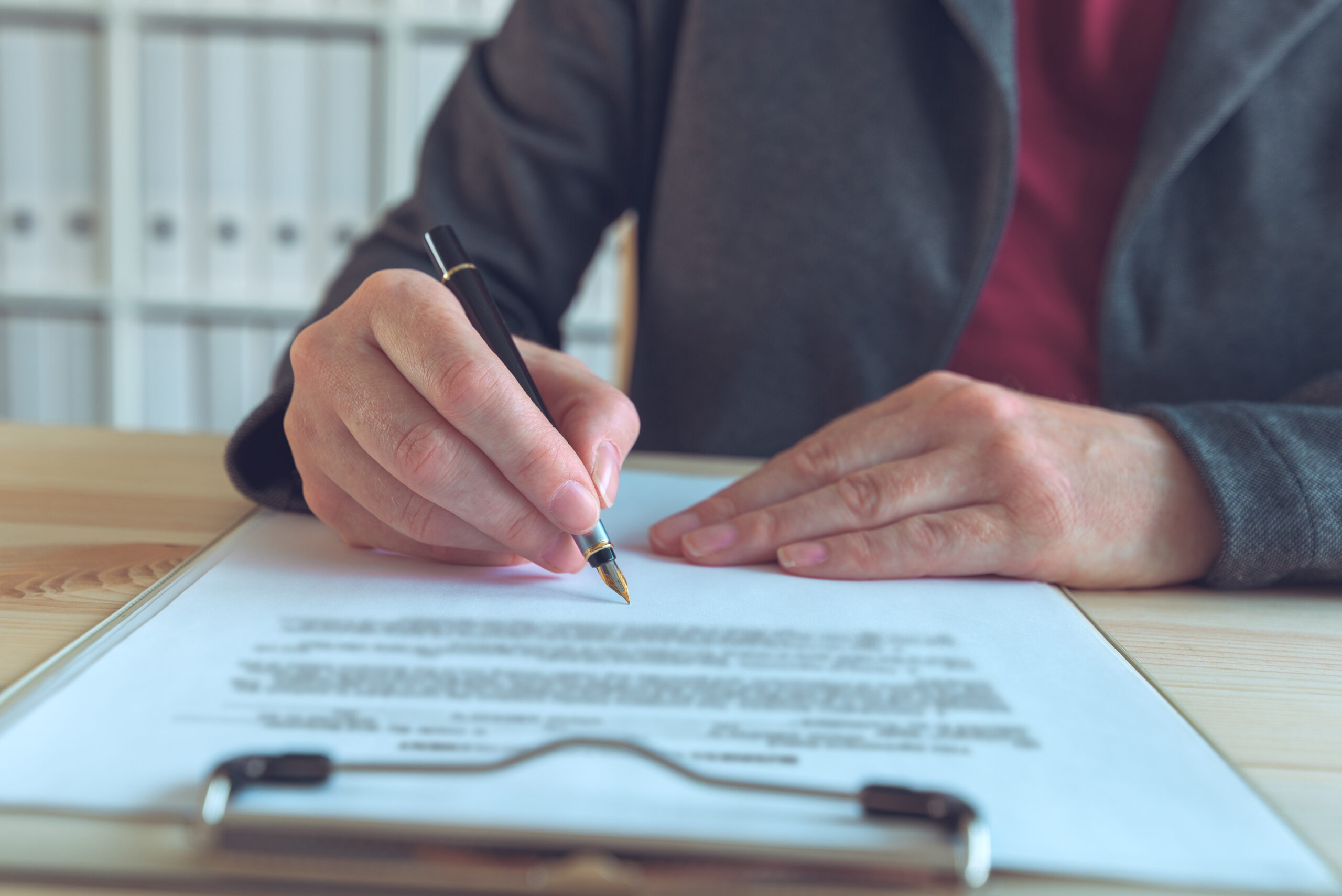 Businesswoman signing contract and business partnership agreement at office desk